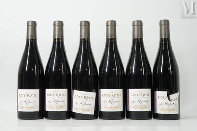 six bottles of wine are lined up in a row on a table