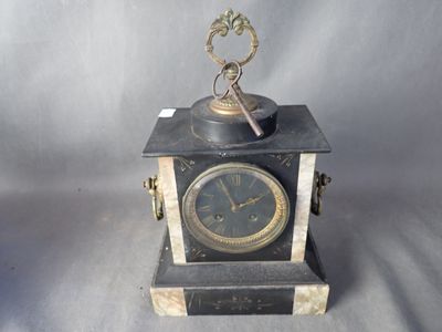 une petite horloge surmontée d'une clé