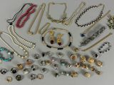 many different types of necklaces and bracelets laid out on a table