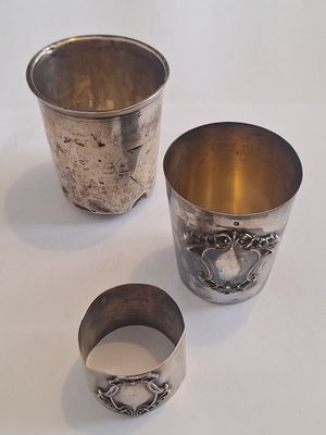 trois tasses en argent posées l'une à côté de l'autre sur une table