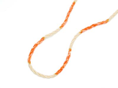 collier de perles orange et blanches sur fond blanc