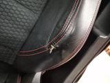 the seat of a car with red stitching on it