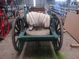 a wagon with a hose attached to it in a barn