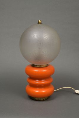 an orange and white table lamp with a glass ball on top of it