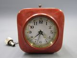 une horloge rouge posée sur une table