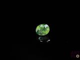 a close up of a green diamond on a black surface