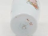 a white vase with a floral design on it