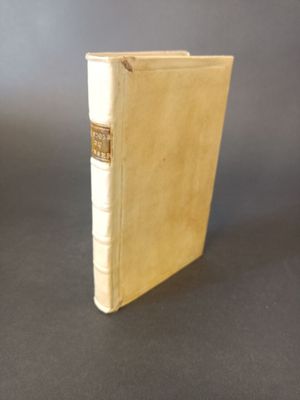 an old book sitting on top of a table on a black surface