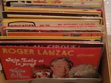a lot of records in a box on the floor