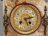 a clock that is on the wall with a gold frame