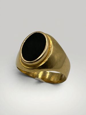 une bague en or avec une pierre noire au centre