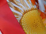 a close up of a tie with a sunflower design on it