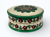 a small round box with a flower design on it