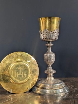 une assiette en or et une coupe en argent posées sur une table