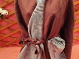 an image of a mannequin wearing a brown and white plaid shawl