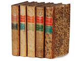 a set of four old books sitting on top of each other
