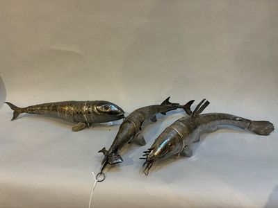 trois poissons posés sur une surface blanche
