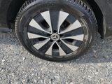 the tire of a black car with a flat tire on a gravel road