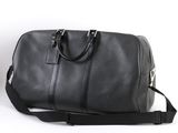 un sac de voyage noir posé sur une surface blanche