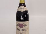 an old bottle of wine sitting on top of a white table