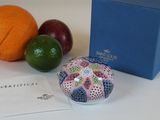 une boîte bleue avec un couvercle bleu, à côté d'une boîte d'oranges et de citrons verts