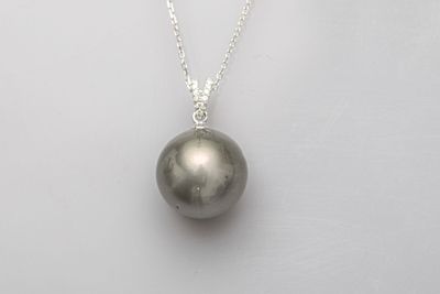 un pendentif en perle noire monté sur une chaîne en argent