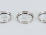three pieces of silver jewelry sitting on top of a white surface