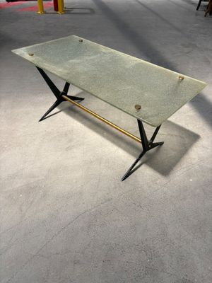 une photo d'une table basse en verre avec un piètement en métal et un plateau en verre