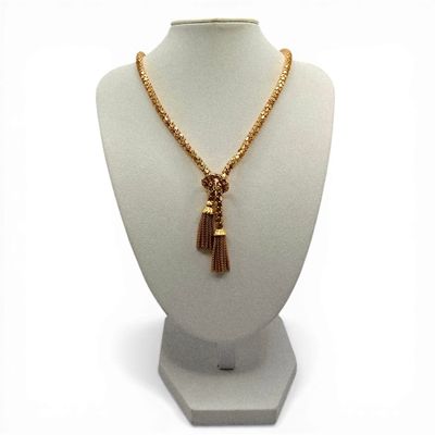 necklace with gold chain and tassel on mannequin base