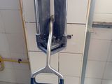 a toilet with a metal handle in a bathroom stall