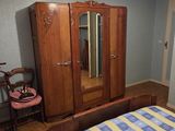 a bedroom with a bed, dresser, and mirror in it