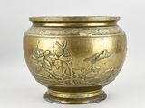 a gold vase with a bird and flowers design on it