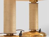pair of brass table lamps with linen lampshads on each of them