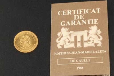 une pièce d'or posée à côté d'une autre pièce d'or sur une surface noire