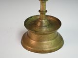 a gold candle holder on a white table