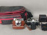 un appareil photo, un étui pour appareil photo, un appareil photo et d'autres objets disposés sur une table