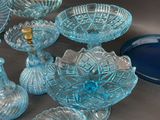 many glass bowls and vases sitting on a table