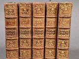 six vieux livres sont empilés sur une table