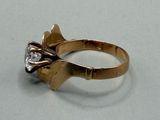 a gold ring with a diamond on it on a table