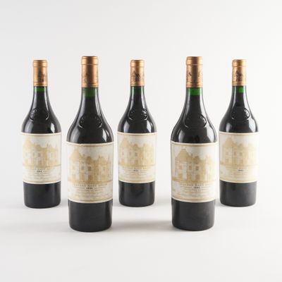 quatre bouteilles de vin sont alignées sur une surface blanche