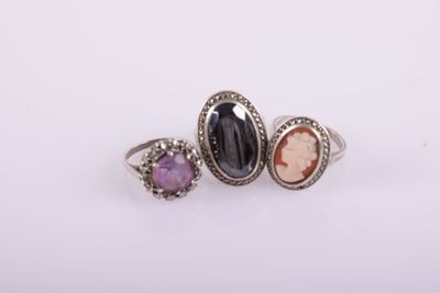 three different colored stone rings sitting on top of each other