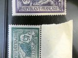 two different stamps are on a black surface with a small piece of paper next to them