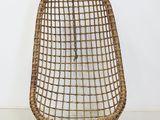 a wicker chair with a metal frame on a white floor