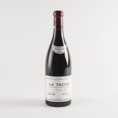 une bouteille de vin rouge posée sur une table blanche