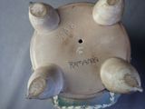 a small vase with four small birds on it