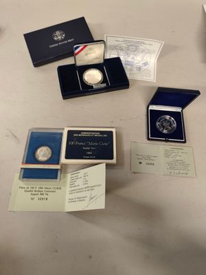 some of the silver coins are sitting on a table with other items