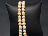 un gros plan d'un bracelet de perles posé sur un coussin