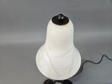 a white lamp with a black base on a table
