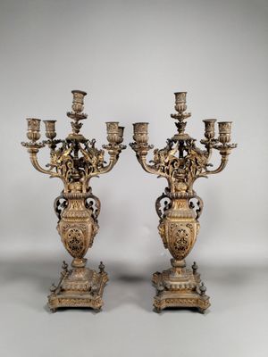 paire de chandeliers anciens en laiton sur des socles, ornés de fleurs et de feuilles