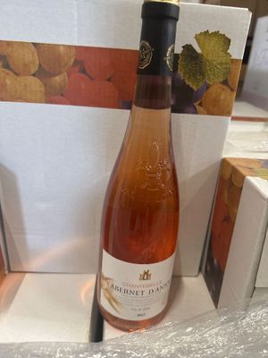 une bouteille de vin posée sur une table à côté d'une boîte de biscuits